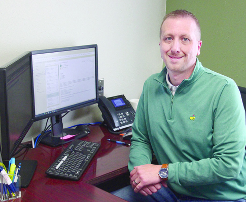 NEW VICE PRESIDENT -- Andy Elder at his desk in Great Plains State Bank, Petersburg.
