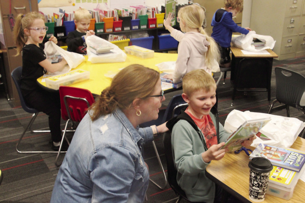 GRAND OPENING -- First grade students were excited to open their packages of books in the classrooms. Tina Hellbusch, school librarian, is in the foreground.