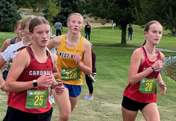 Kate Maricle (25) and Johnna Spence (28) lead a group of runners in the West Holt Invitational. Both girls set personal bests for the course. This was the first meet back from injury for Johnna.