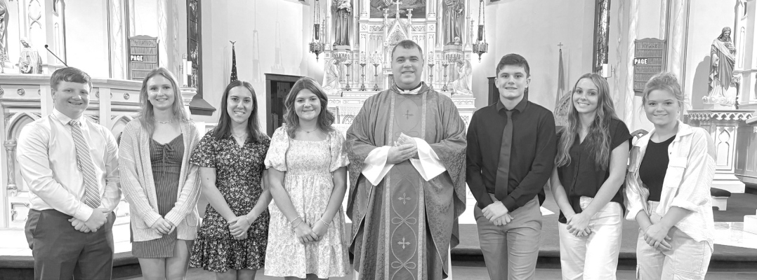 Pictured left to right: Aiden Klein, Reese Stuhr, Jovie Borer, Harlie Tyler, Father John Norman, Landyn Veik, Camry Kittelson, and Tessa Barlow.