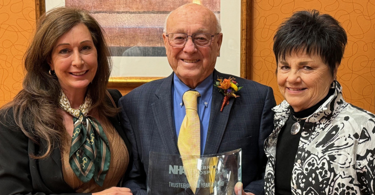 John Mlnarik AMH Board of Trustees President (ctr), is shown with Diane Brugger, AMH CEO (left), and his wife, Barb Mlnarik (right) after being recognized as the NHA 2024 Trustee of the Year. He has volunteered to serve on AMH’s board of trustees for the past 39 years.