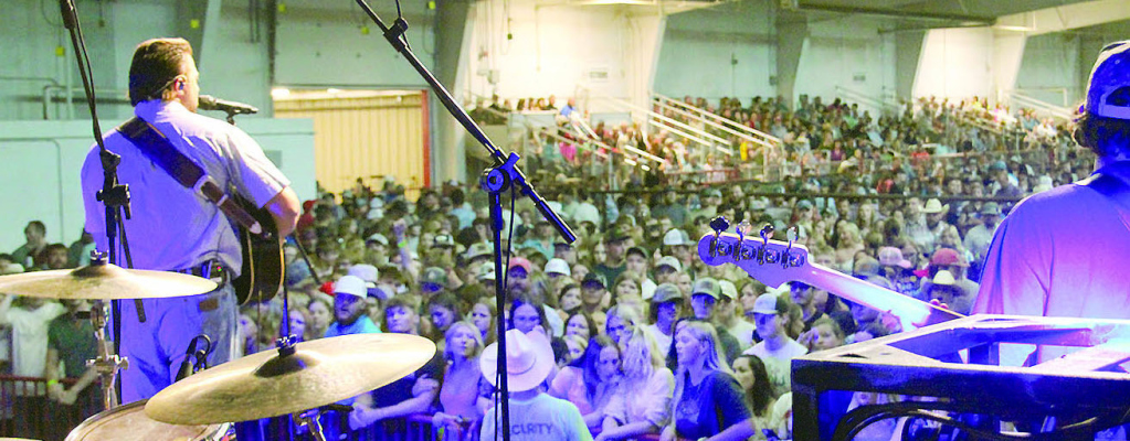 BIG CROWD -- Saturday night’s country music concert was moved into the Niewohner Arena due to threatening storms. Walker Montgomery, the opening performer, played to a crowd of 1,500 people. Only a portion of the audience can be seen in this photo. Above, front row fans roar approval for headline attraction, the Eli Young Band (inset).