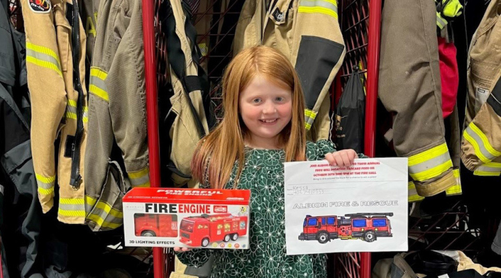 Kessa Rasmussen receiving the fire truck prize for her drawing