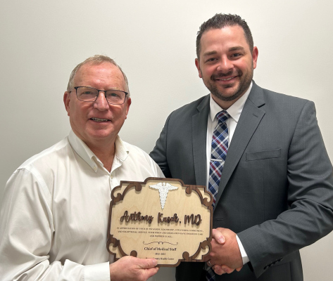 Caleb Poore, CEO present plaque to Anthony Kusek, MD