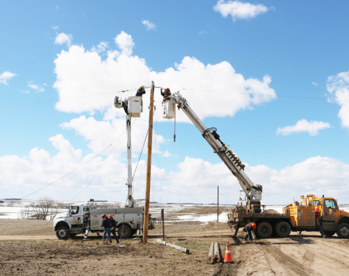 Crews from Cornhusker Public Power District and Niobrara Valley Electric Membership Corporation work together to string line south of Howells on March 21.