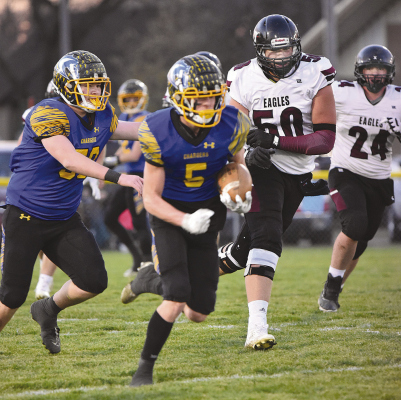 OFF AND RUNNING -- Trevor Carraher (5), with the help of Brody Schmeits (58) runs away from BDS defenders during last Friday night’s D2 semifinal game. Photo: Dee Schalk • Cedar Valley News