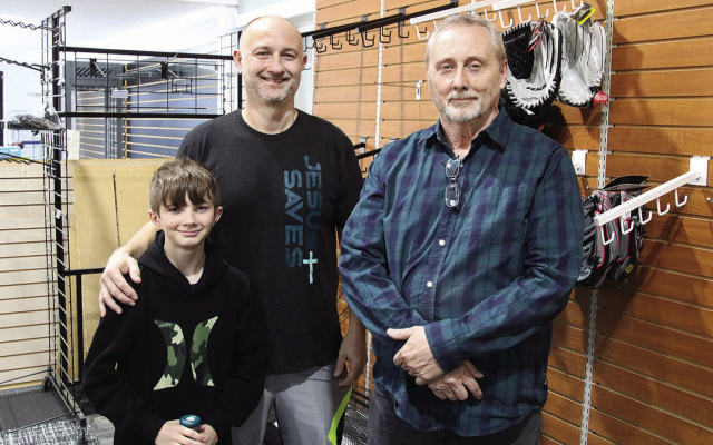 SPORTS STORE TO OPEN -- Preparing for opening of the new Main Street Sports store in Albion last week were, l.-r., Reid Buck with his father, John, and grandfather, Wesley.