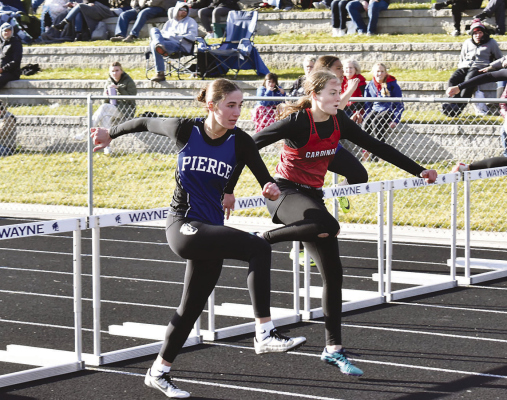 Cardinal senior Ava Buhlmann battles a Pierce opponent stride for stride in the Wayne Blue Devil Invitational. Buhlmann took gold in the 300 meter hurdles and was a member of the winning Lady Cardinal 4x400 meter relay team. (Photo, Nolan Vandenburg, Boone Central Schools)