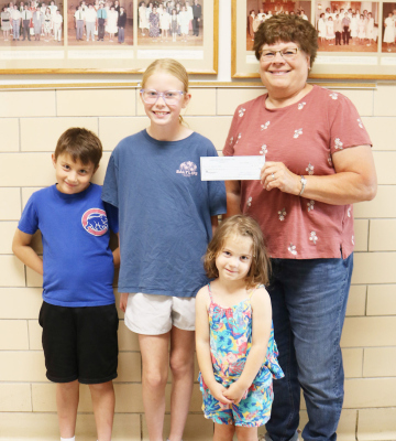 Cornhusker Public Power District Goodwill Fund Trustee Cindy Hemmer (right) presents $300 to St. Michael’s School for archery materials. Accepting the check are St. Michael students.
