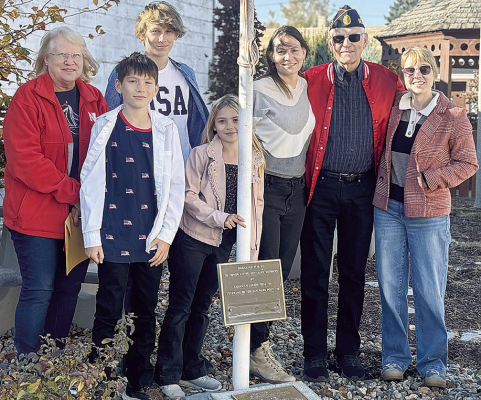 LIVING VETERAN AWARD -- Bill Schriver (second from right) and his wife Dee (left) attended the honorary flag raising at the downtown mini-park Monday with their family members. Courtesy Photo