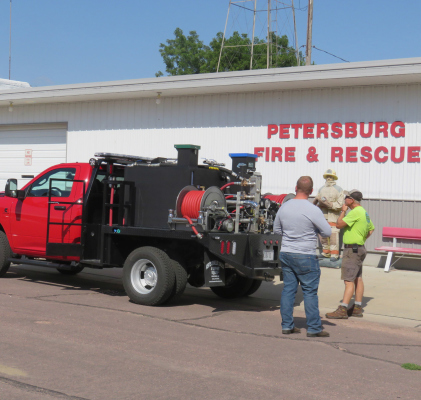 The Petersburg Rural Fire District board recently purchased a new grass rig for use by the Petersburg fire Department in fighting grass fires. The new rig has a 450-gallon tank along with a 10-gallon foam applicator and two hose reels. This unit also has department personal wells behind the cab which allow firemen to stand on the rig while the unit is in motion. Remote controls are located both in front and in the rear for easier access while in use.