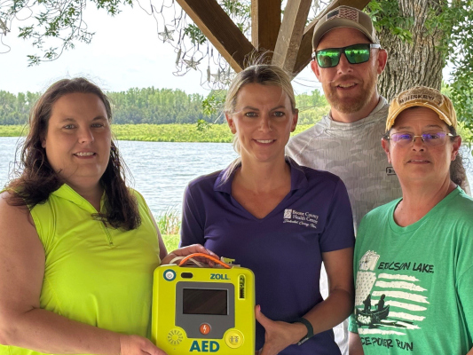 BCHC Representative Nicole Levander delivers AED to Ericson Lake Corporation Board members Ashley Kaiser, Jason Daharsh and Cyndi Schure.