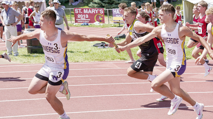 RELAY COMPETITION -- Riverside’s Jack Molt, l., takes the baton from teammate Nicholas Berger on the way to third place in the 4 x 100 meter relay at the state meet. Photo by Brook Curtiss