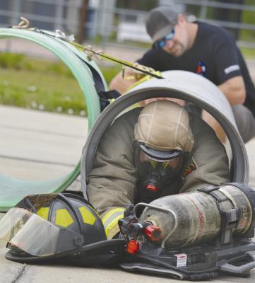 TIGHT SPOT -- A firemen in full gear crawls thorugh a small concrete pipe as part of the search and rescue training at the Mini Fire School last Saturday. Photos and information courtesy of Whitney Paulson, Albion VFD secretary