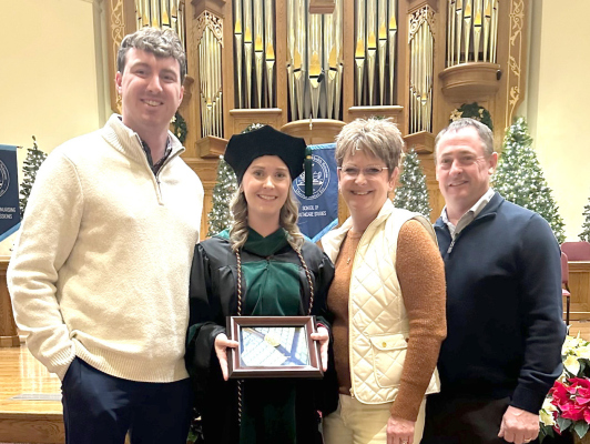 Dr. Kramer with her husband Kyle and parents John and Tracy permitting. Beckman following her Early Career Alumni Award recognition.